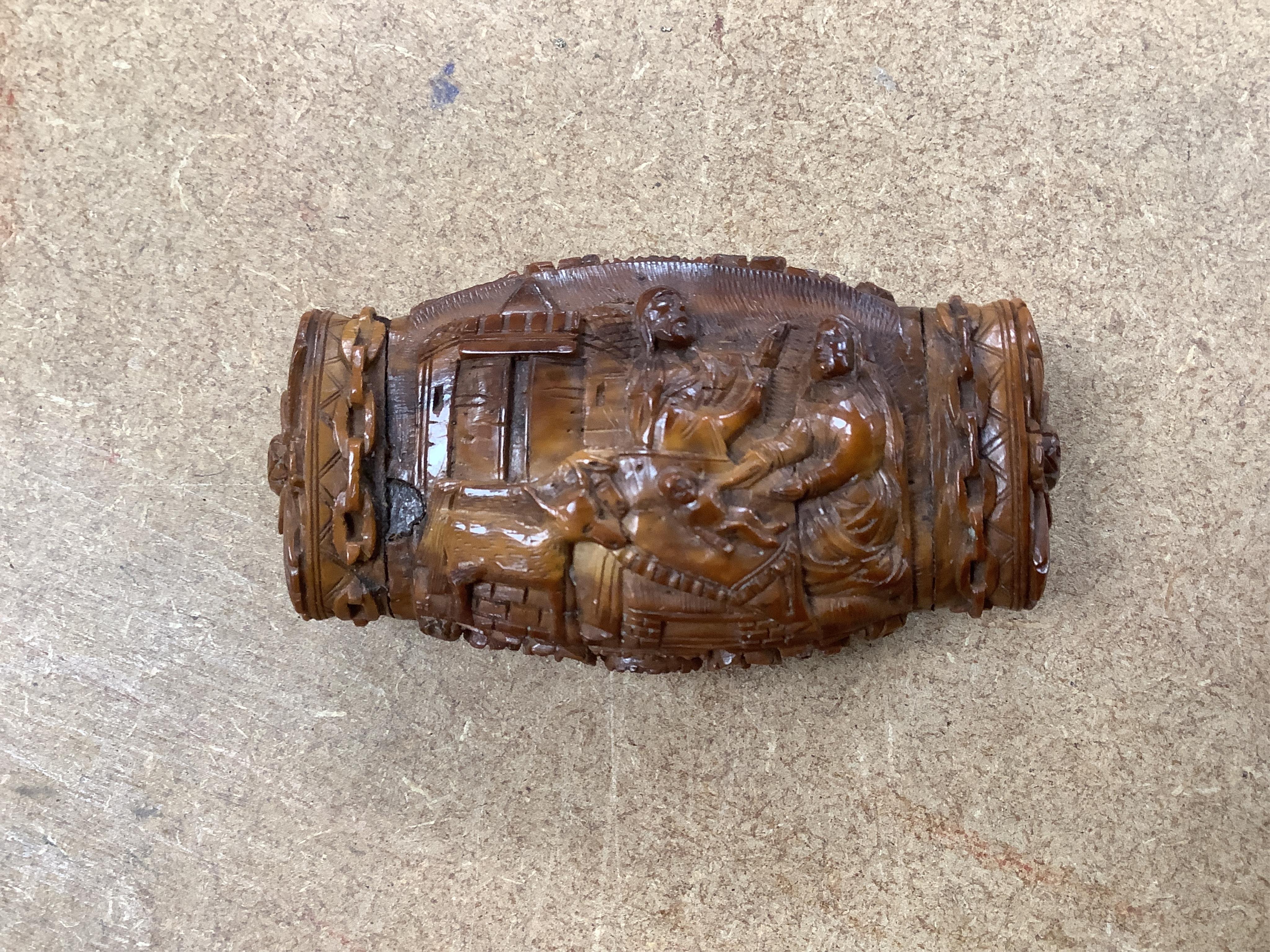 An 18th / 19th century European carved figural coquilla nut snuff box, 8.5cm wide